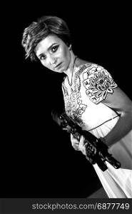 Portrait of attractive woman in military style holding gun in hands