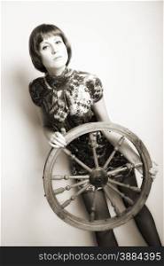 portrait of attractive woman with wooden wheel. indoor shot