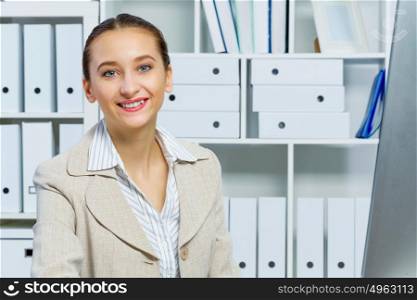 Portrait of attractive woman working in office on computer. Office work