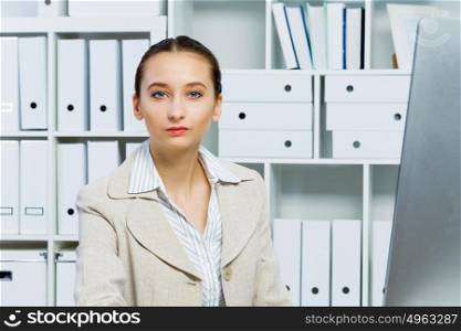 Portrait of attractive woman working in office on computer. Office work