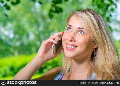 Portrait of attractive young blonde woman talking on the phone
