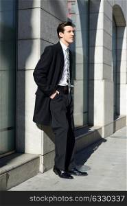Portrait of attractive young businessman in urban background