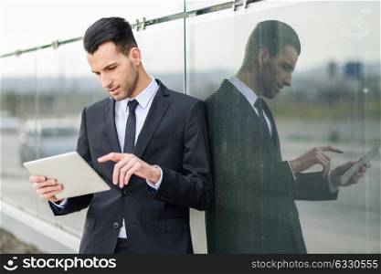 Portrait of attractive young businessman with a tablet computer in an office building