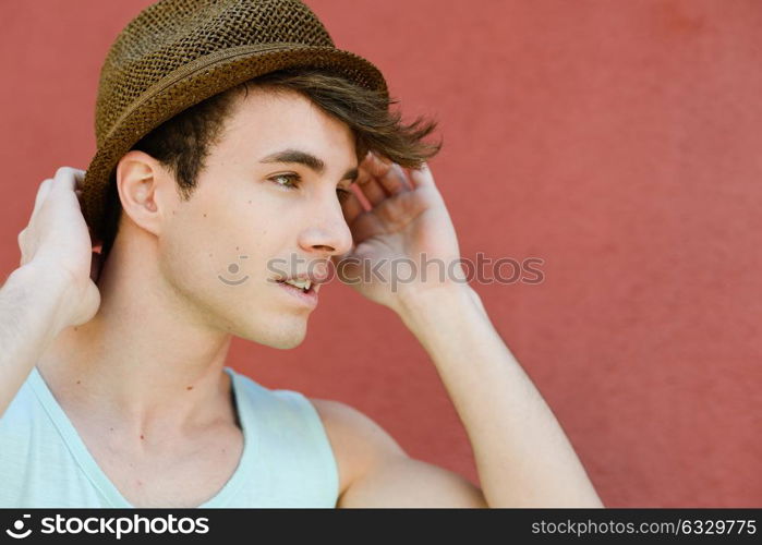 Portrait of attractive young man in urban background wearing a sun hat