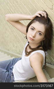 Portrait of attractive young redhead Caucasian woman sitting on fire escape.