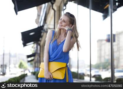 Portrait of attractive young woman on open air. Woman making a call me sign outdoors