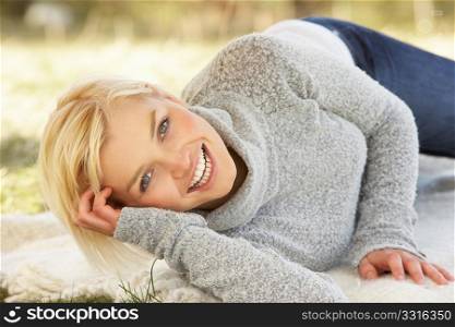 Portrait Of Attractive Young Woman Relaxing On Grass
