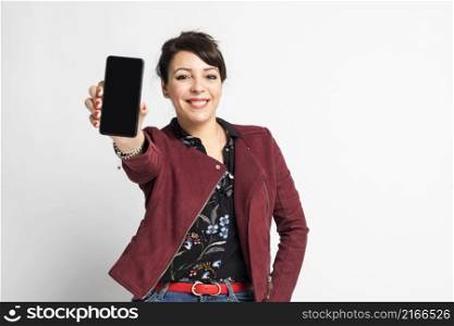 Portrait of attractive young woman with white smile, showing empty smartphone screen, demonstrate an app or online shopping store, studio background
