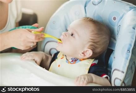 Portrait of baby boy eating puree from spoon