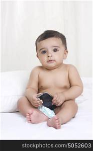 Portrait of baby holding mobile phone