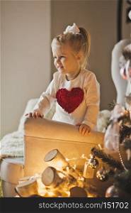 Portrait of baby in Christmas decorations.. The child plays with the ornaments on the Christmas tree 7277.