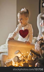 Portrait of baby in Christmas decorations.. The child plays with the ornaments on the Christmas tree 7278.