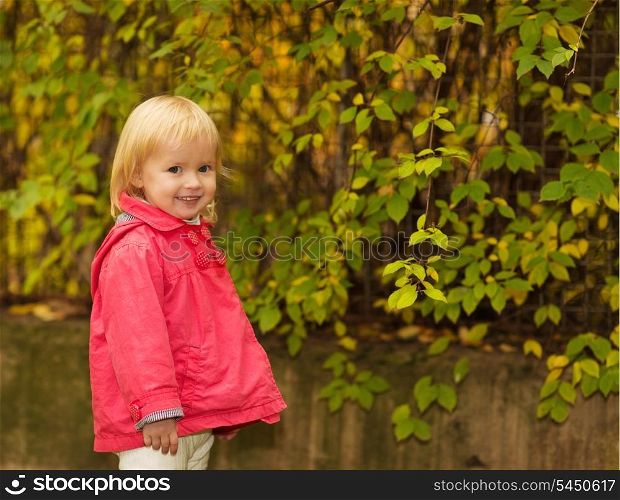 Portrait of baby in red coat outdoors