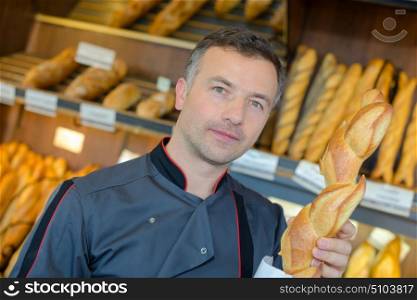 Portrait of baker holding baguette