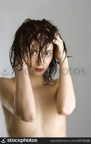 Portrait of bare attractive Caucasian redhead young woman with wet hair.