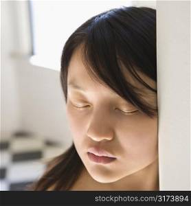 Portrait of bare pretty young Asian woman with eyes closed.