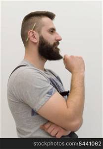 portrait of bearded hipster handyman with pen behind ear isolated on white background