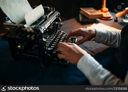 Portrait of bearded literature author in glasses typing on vintage typewriter. Creative people concept. Literature author in glasses typing on typewriter