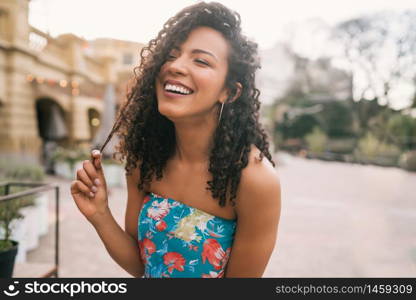 Portrait of beautiful afro american latin confident woman laughing in the street. Outdoors.