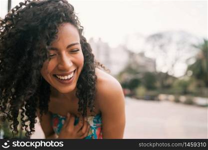 Portrait of beautiful afro american latin confident woman laughing in the street. Outdoors.