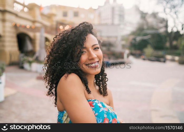 Portrait of beautiful afro american latin confident woman laughing in the street. Outdoors.