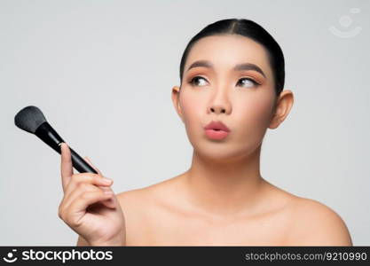 Portrait of Beautiful Asian woman holding makeup blusher brush. Skin care healthy hair and skin close up face beauty isolated over background. Cosmetology and Spa concept.