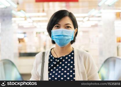 Portrait of Beautiful Asian woman in face mask with new normal life. Confident Young Female wears surgical mask for protect and prevent pandemic corona or covid-19 virus in public city.