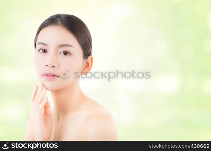 Portrait of beautiful asian woman makeup of cosmetic - girl hand touch mouth or lip and relax on attractive face with skin healthcare concept on green nature background.
