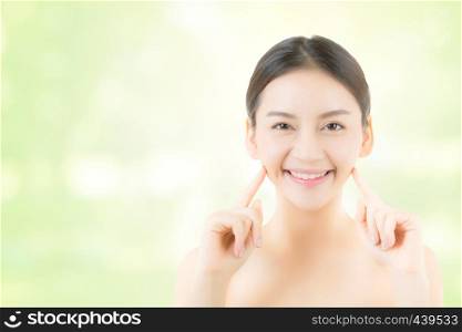 Portrait of beautiful asian woman makeup of cosmetic - girl hand touch cheek and smile on attractive face with skin healthcare concept on nature green background.