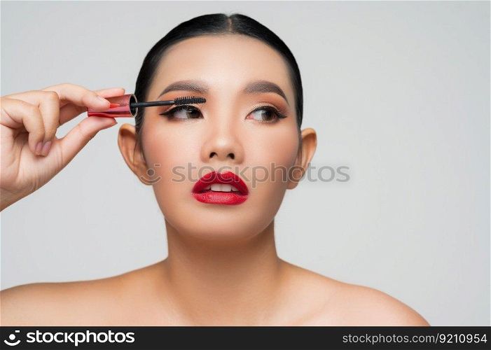 Portrait of Beautiful Asian woman with mascara in hand. Skin care healthy hair and skin close up face beauty isolated over background. Cosmetology and Spa concept.