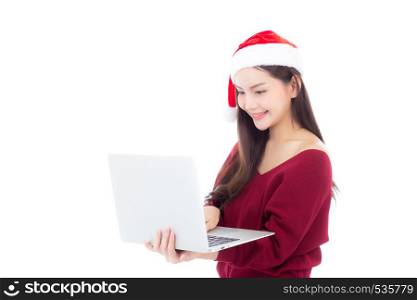 Portrait of beautiful asian young woman in santa hat using laptop computer with happy and smile isolated on a white background, season holiday concept.