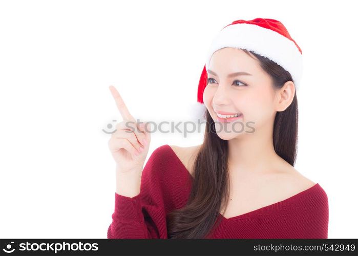 Portrait of beautiful asian young woman pointing something in santa hat smile and happy, girl model isolated on white background, christmas and holiday concept.