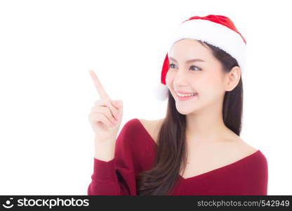 Portrait of beautiful asian young woman pointing something in santa hat smile and happy, girl model isolated on white background, christmas and holiday concept.