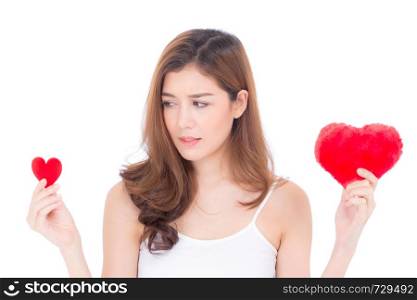 Portrait of beautiful asian young woman smiling holding red heart shape pillow choice big and small isolated on white background, valentines day, holiday concept.