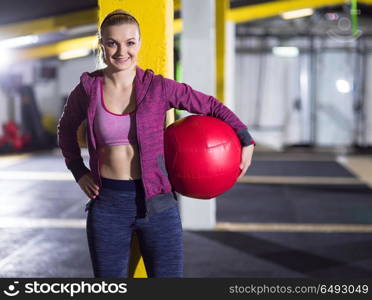 Portrait of beautiful athlete woman with red medicine ball at crossfitness gym. portrait of woman with red crossfitness ball