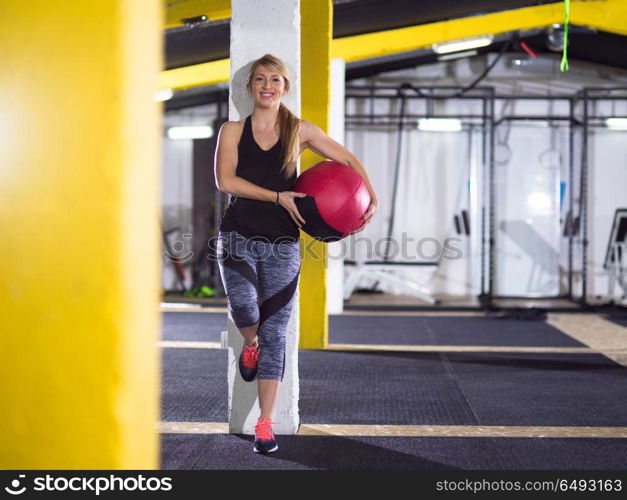 Portrait of beautiful athlete woman with red medicine ball at crossfitness gym. portrait of woman with red crossfitness ball