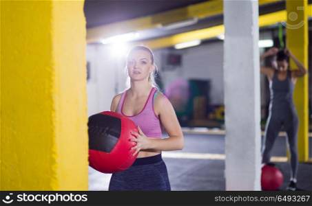 Portrait of beautiful athlete woman with red medicine ball at crossfitness gym. portrait of woman with red crossfitness ball