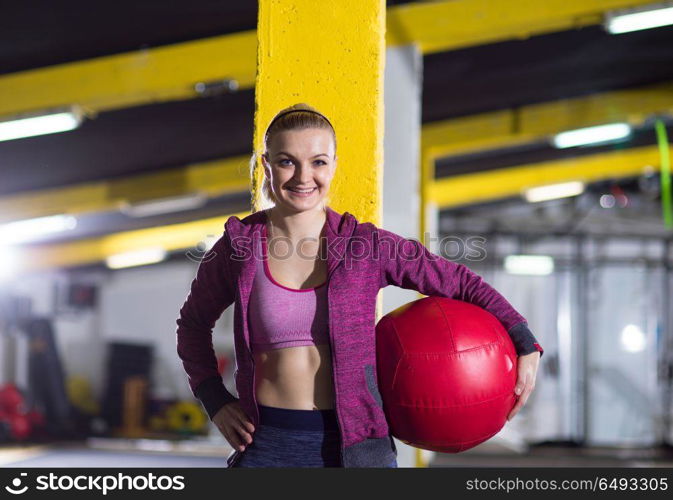 Portrait of beautiful athlete woman with red medicine ball at crossfitness gym. portrait of woman with red crossfitness ball