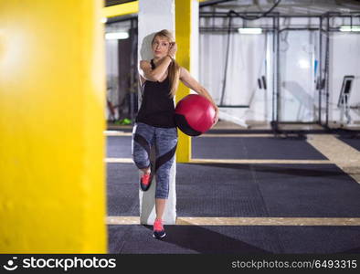 Portrait of beautiful athlete woman with red medicine ball at crossfitness gym. portrait of woman with red crossfitness ball