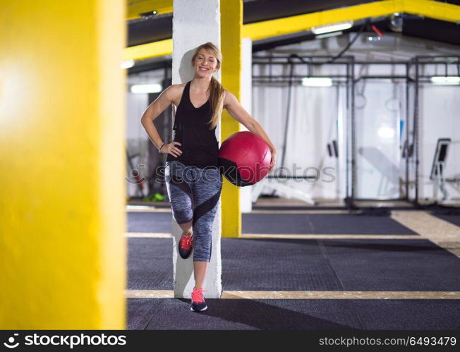 Portrait of beautiful athlete woman with red medicine ball at crossfitness gym. portrait of woman with red crossfitness ball