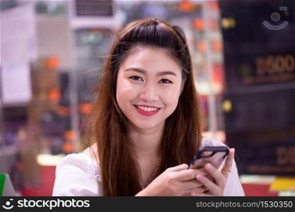 Portrait of Beautiful Attractive Asian woman smile and using smartphone feeling so happiness and fun