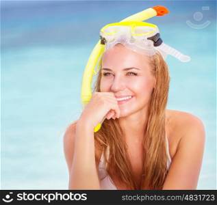 Portrait of beautiful blond girl wearing cute yellow diving mask sitting on the beach, active lifestyle, enjoying water sport, summer vacation concept&#xA;