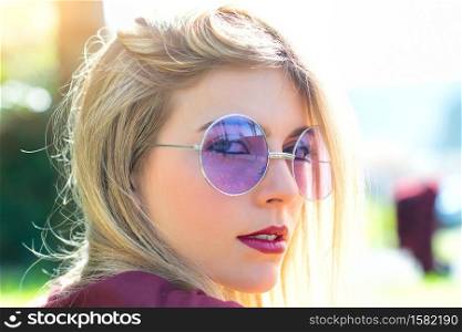 Portrait of beautiful blond girl with transparent purple eyeglasses.