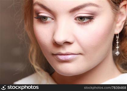 Portrait of beautiful blond pensive girl. Closeup of face thoughtful young woman with professional makeup.