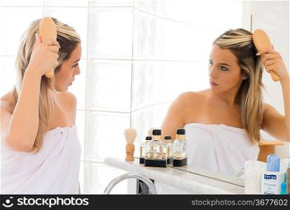 portrait of beautiful blond woman doing daily morning routines in front of the mirror