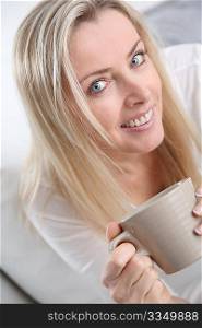 Portrait of beautiful blond woman drinking tea