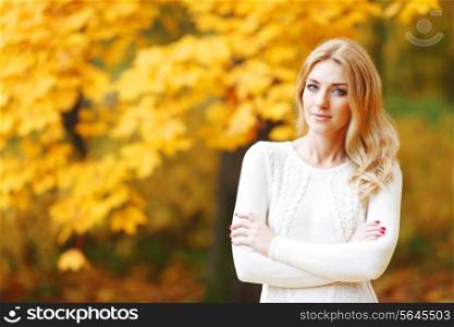 Portrait of beautiful blond woman in autumn park