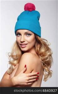 Portrait of beautiful blond woman in blue hat. Smiles.