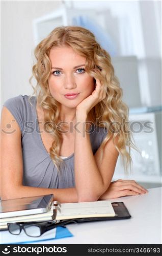 Portrait of beautiful blond woman in office with hand on chin