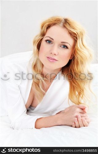 Portrait of beautiful blond woman relaxing in bed